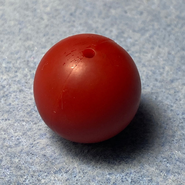 red silicone bead on a textured gray background