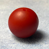 red silicone bead on a textured gray background