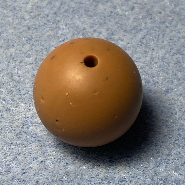 brown speckled silicone bead on a textured gray background