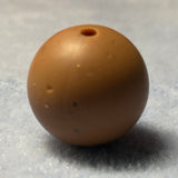 brown speckled silicone bead on a textured gray background
