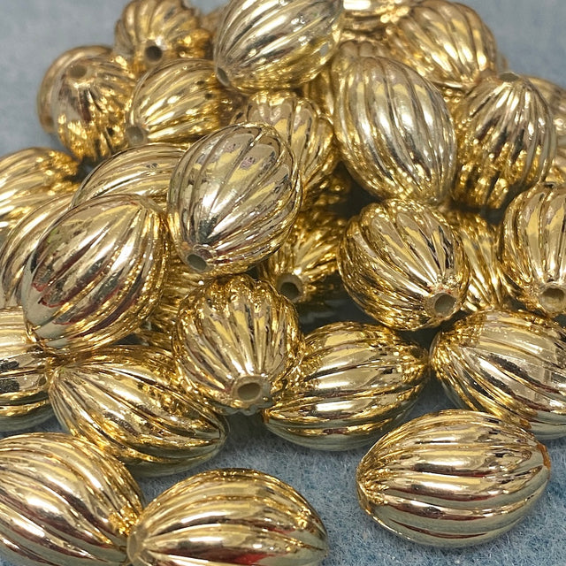 Gold beads with textured surface on a gray background