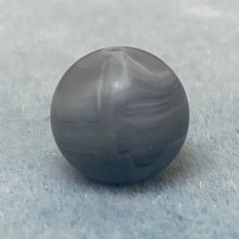 grey marble like round silicone bead on a textured gray background