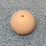 blush pink round silicone bead on a textured gray background