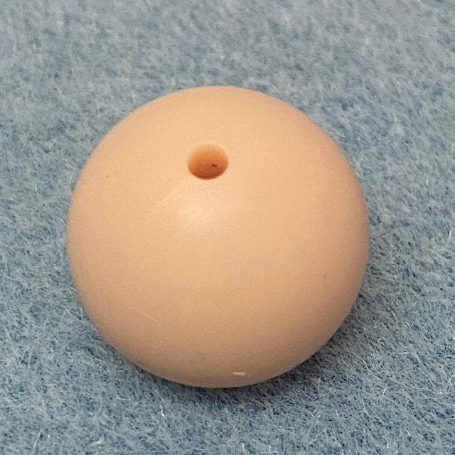 beige neutral nude round silicone bead on a textured gray background