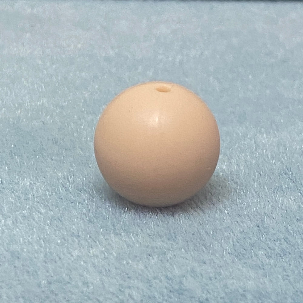 Beige bead with a central hole on a gray background