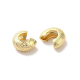 close up of 2 crimp covers with textured gold surface
