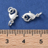 2 anti tarnish plated jewelry clasps with rings for the purpose of making a closure on a necklace or bracelet on a blue background with a wood ruler for size comparison