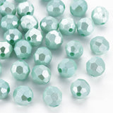Light mint green faceted glass beads scattered on a white background.