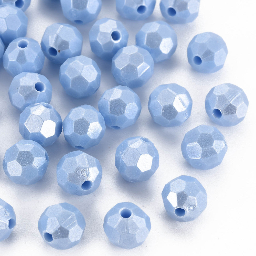 Light blue faceted round beads with pre-drilled holes, scattered on a plain white background.
