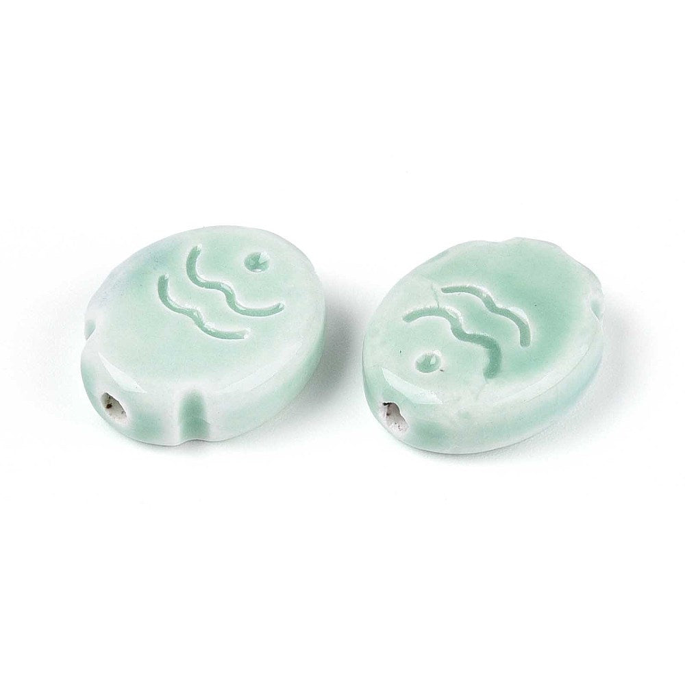 Two pink ceramic fish beads with wave designs on a white background