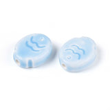 Two light blue fish ceramic beads with wave design on a white background