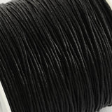 Close-up of a spool of black cord on a white background