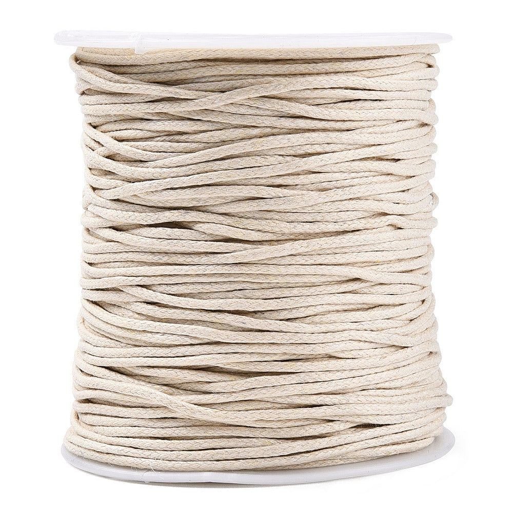 Spool of beige cord on a white background