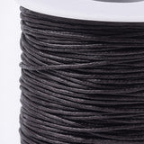 Close-up of a spool of brown thread on a white background