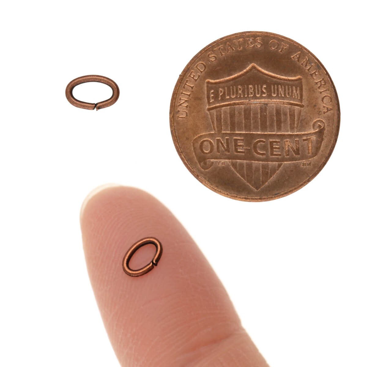 Small copper ring next to a penny on a white background