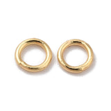 Pair of gold closed soldered jump rings on a white background