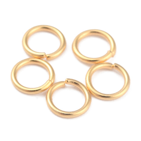 Set of gold connecting jump rings on a white background