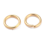Pair of gold connecting jump rings on a white background