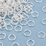 Silver jump rings scattered on a blue background
