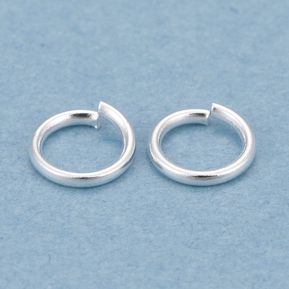 Two silver  connector rings on a light blue background