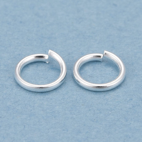 Two silver  connector rings on a light blue background