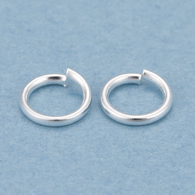 Two silver  connector rings on a light blue background