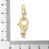 Gold clasp with clear stones next to a ruler for scale on a white background