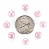 Pink beads arranged around a dime on a white background