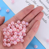 Hand holding shiny pink pearl beads on a blue and white background