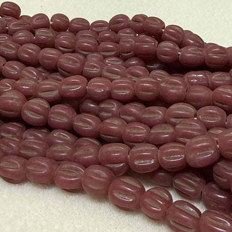 Close-up of a string of maroon beads on a light background
