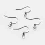 close up of a collection of silver anti tarnish ear wires with a white background and a wood ruler to show sizing