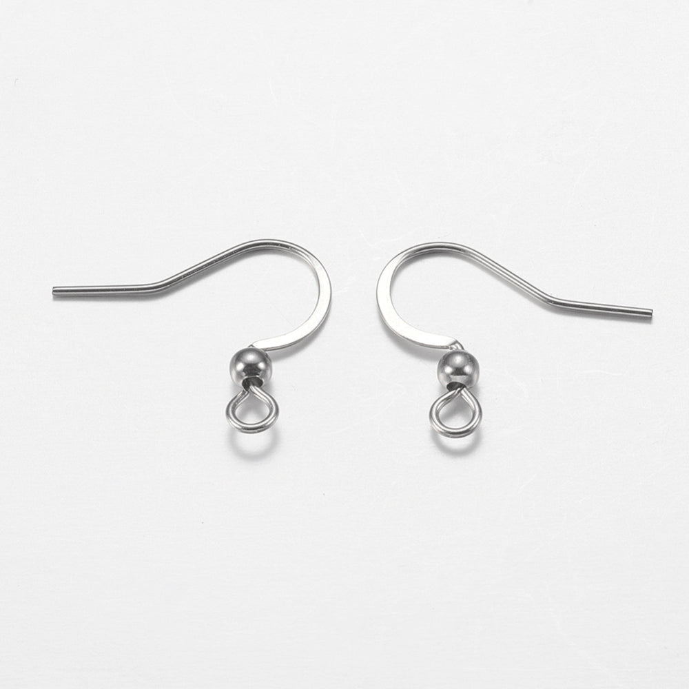 close up of a collection of silver anti tarnish ear wires with a white background and a wood ruler to show sizing