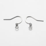 close up of a collection of silver anti tarnish ear wires with a white background and a wood ruler to show sizing