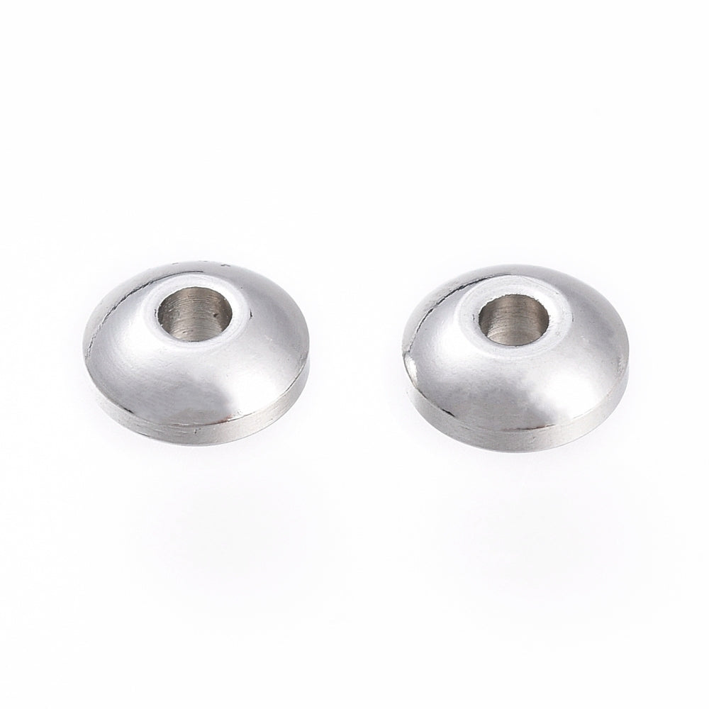 Two silver metal beads on a white background