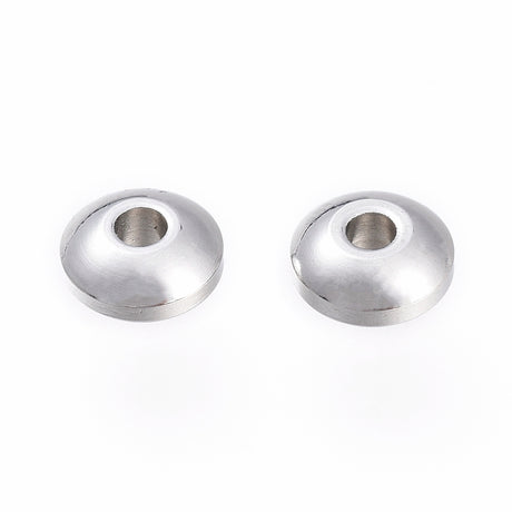 Two silver metal beads on a white background