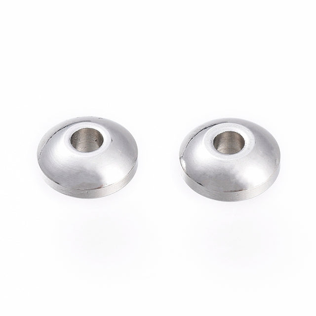 Two silver metal beads on a white background