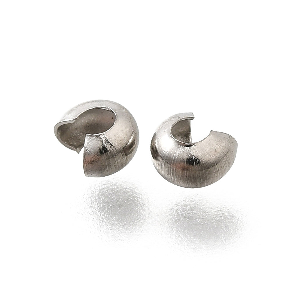 two anti tarnish finished crimp cover beads on a white background