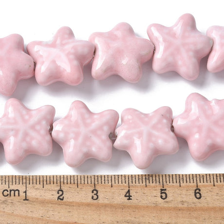 Sea themed Star-shaped pink beads with a ruler for scale on a white background