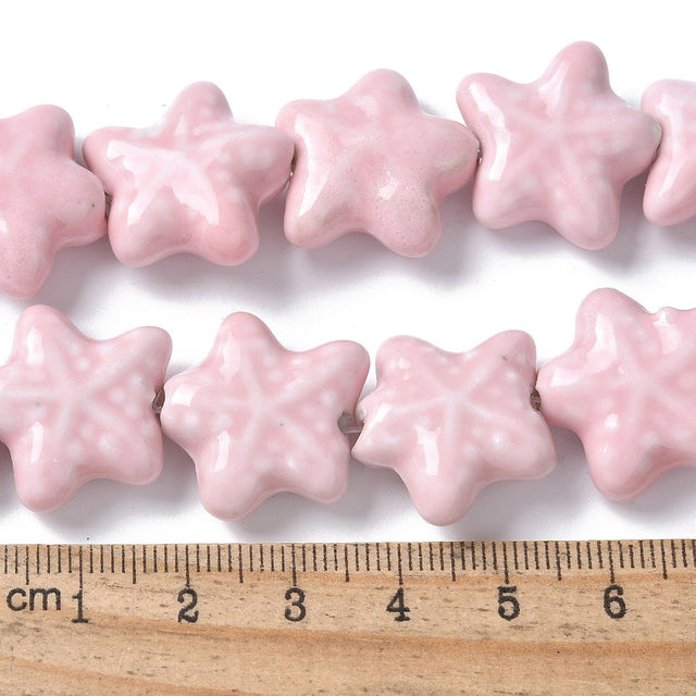 Sea themed Star-shaped pink beads with a ruler for scale on a white background