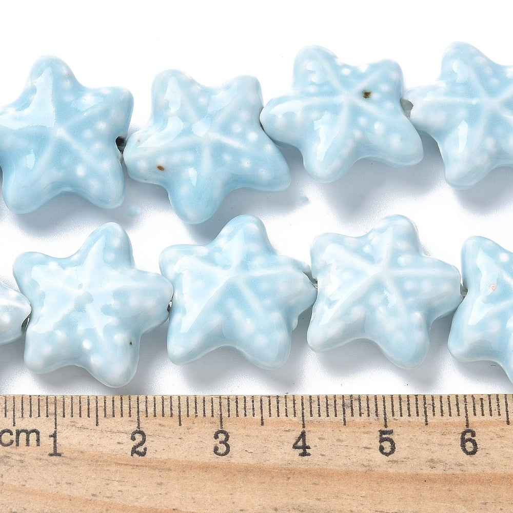 Starfish Star-shaped light blue beads with a ruler for scale on a white background