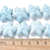 Starfish Star-shaped light blue beads with a ruler for scale on a white background