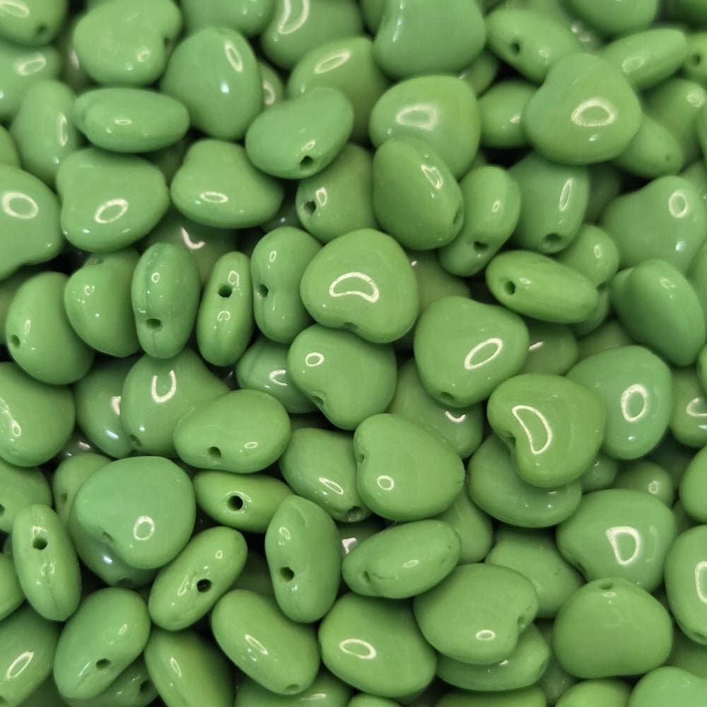 Close-up of green heart-shaped beads with a glossy finish.