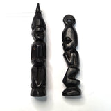 Two black wooden african folk art carvings on a white background 