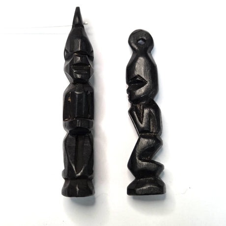 Two black wooden african folk art carvings on a white background 
