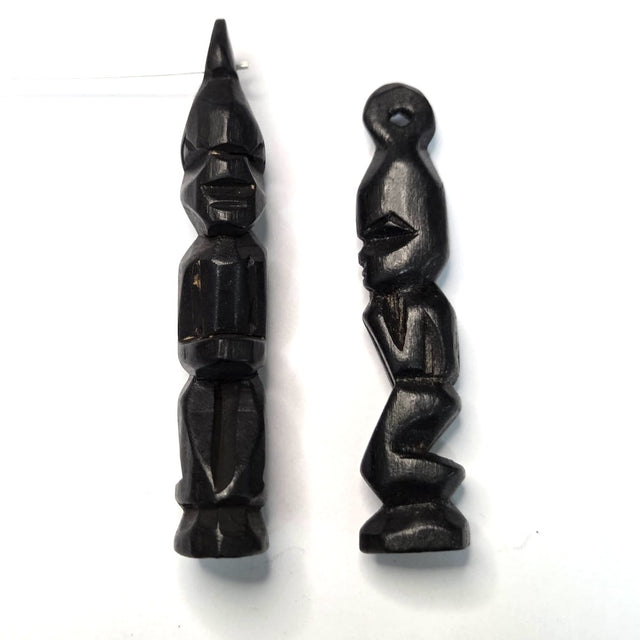 Two black wooden african folk art carvings on a white background 