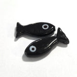 Two black fish-shaped beads on a white background