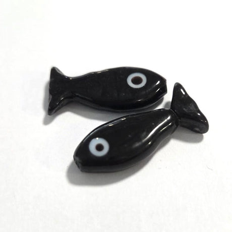 Two black fish-shaped beads on a white background