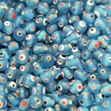close up of aqua blue transparent beads with colourful eyes and showing threading holes for the purpose of making jewelry and craft