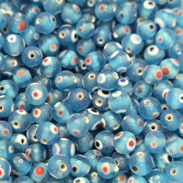 close up of aqua blue transparent beads with colourful eyes and showing threading holes for the purpose of making jewelry and craft