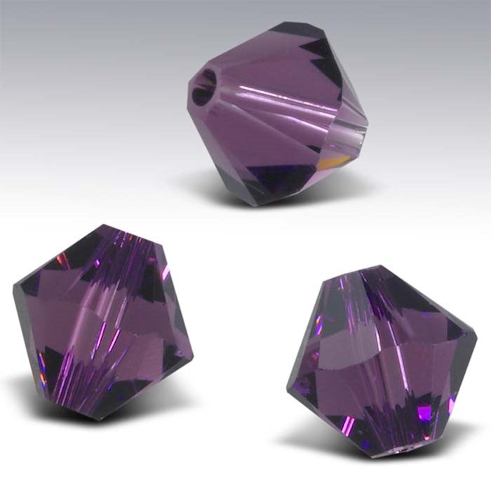 Three purple faceted beads on a gray background